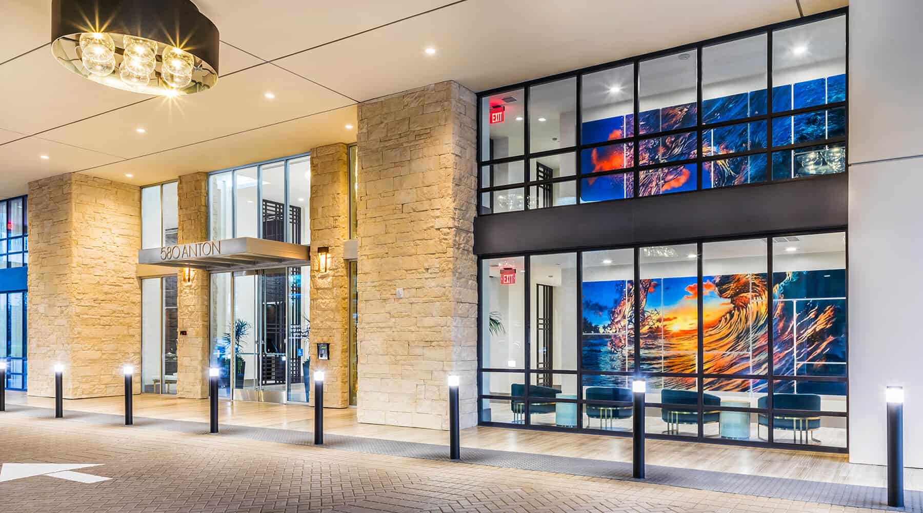 Exterior of 580 Anton with modern lighting, large windows, and vibrant artwork.