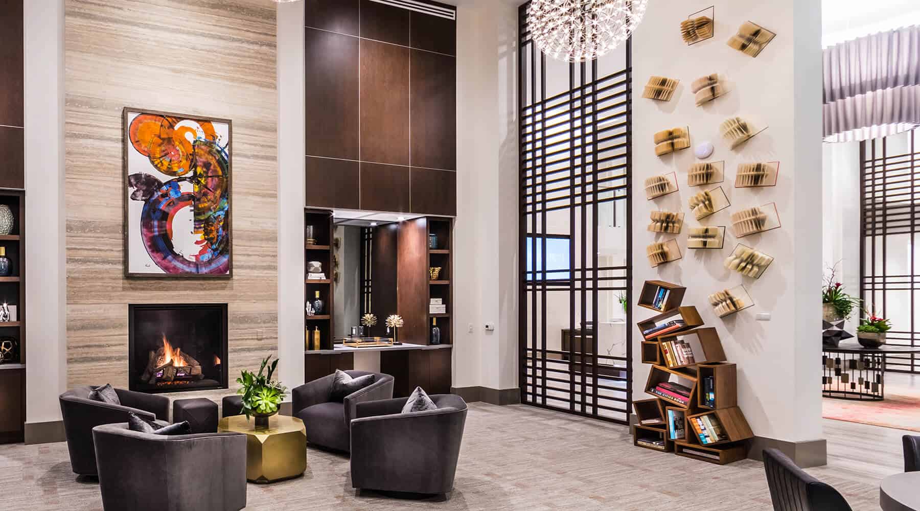 Modern lounge area with a fireplace, artwork, and bookshelves.