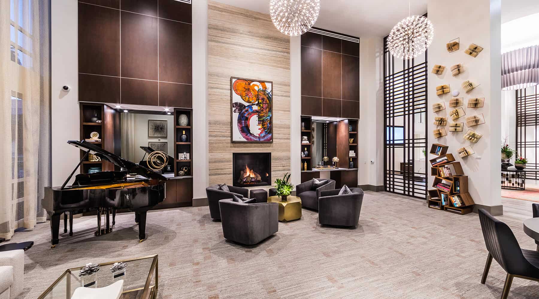 Modern lounge area with a fireplace, artwork, and bookshelves.